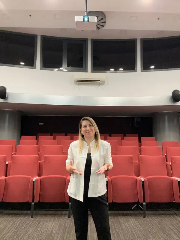 Selvi Binici Dereli, kırmızı koltuklu eğitim salonunda